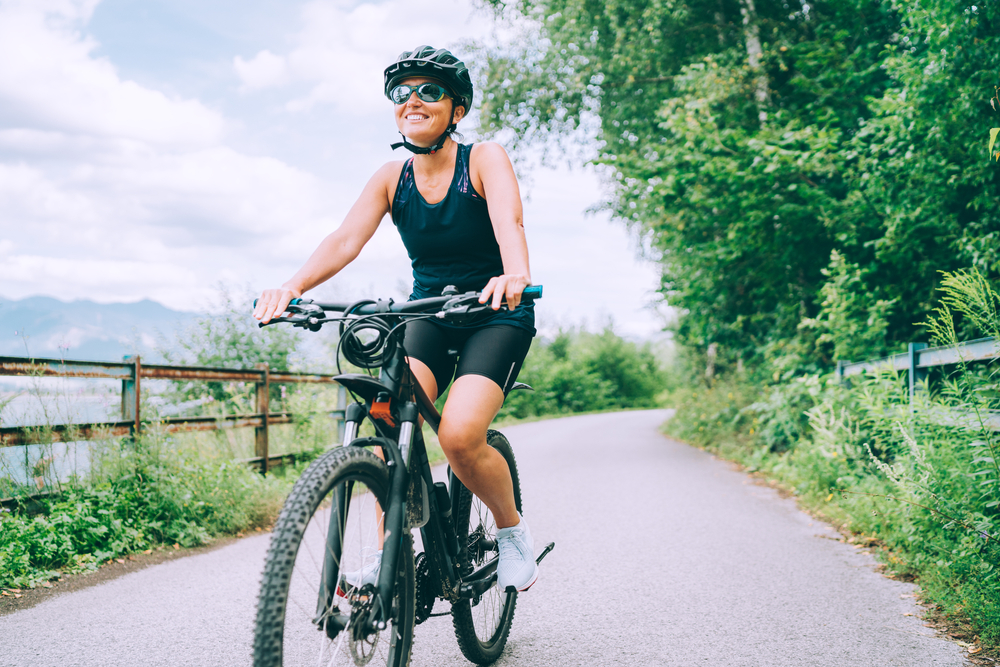 A woman riding a bicycle as part of cross-training to prevent a knee injury